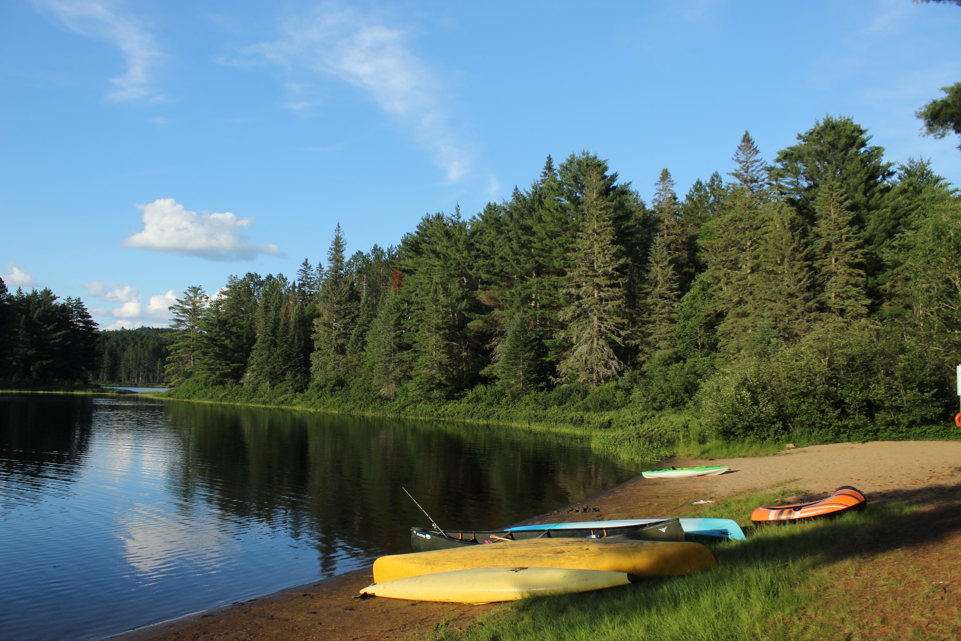 kayaks and canoes sitting on lake shore
